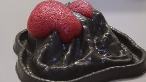 Volcan miniature en pâte avec de la mousse rouge, expérience au bicarbonate et au vinaigre
